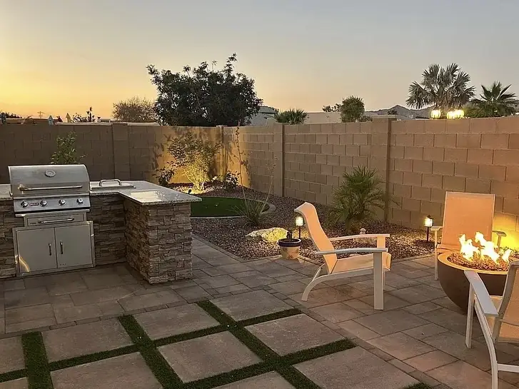 Custom outdoor kitchen and koi pond at dusk